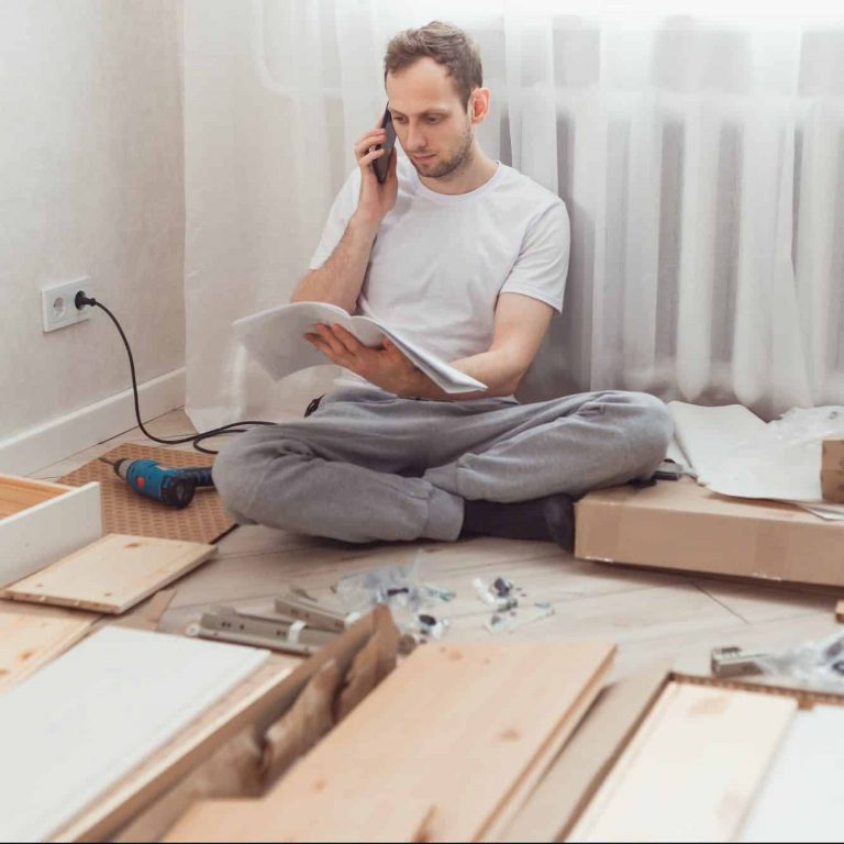 Man customer calls to help center at home during assembling new furniture, calling for a master.